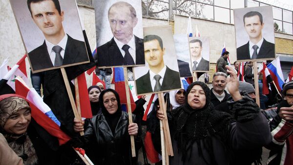 Syrians hold photos of Syrian President Bashar Assad and Russian Prime Minister Vladimir Putin in Damascus, March 4, 2012. - Sputnik International