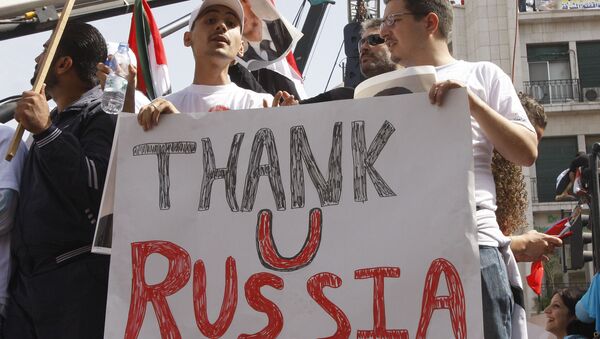 In this Oct. 12, 2011 file photo, supporters of the Syrian government hold a pro-Russian banner to show their support for President Bashar Assad and to thank Russia and China for blocking a U.N. Security Council resolution condemning Syria for its brutal crackdown, during a demonstration in Damascus, Syria. - Sputnik International