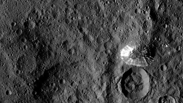 Ceres' four-mile tall mountain, photographed by Nasa's Dawn spacecraft from a distance of 915 miles (1,473 km), has a defined perimeter and shiny, streaked slopes. - Sputnik International