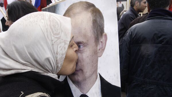 Syrian woman kisses a poster of Russian President Vladimir Putin during a pro-Syrian government protest in front of the Russian Embassy in Damascus, Syria - Sputnik International
