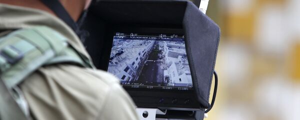 An Israeli soldier uses an unmanned surveillance drone to monitor Palestinian stone throwers. - Sputnik International
