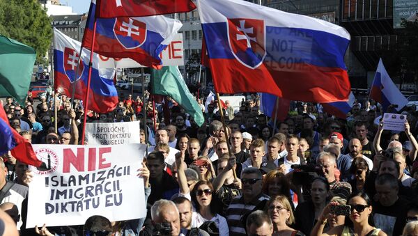 Participants hold flags and banners reading 'No Islamization, migration and dictatorship of the EU' during an anti-immigration rally organised by an initiative called Stop Islamisation of Europe and backed by the far-right People's Party-Our Slovakia on September 12, 2015 in Bratislava, Slovakia. - Sputnik International