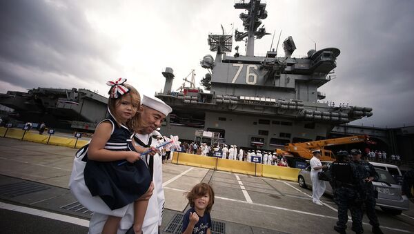 A crew member of the US navy aircraft carrier USS Ronald Reagan stands with his family at the US naval base in Yokosuka, Japan. - Sputnik International