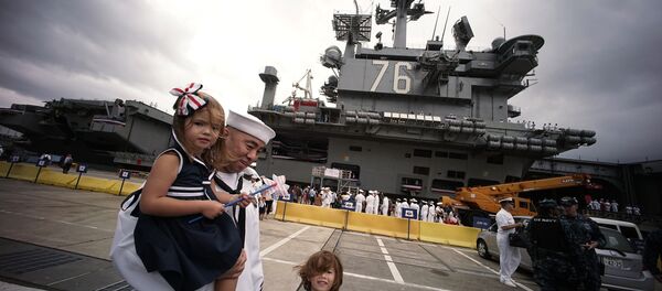 A crew member of the US navy aircraft carrier USS Ronald Reagan stands with his family at the US naval base in Yokosuka, Japan. A crew member of the US navy aircraft carrier USS Ronald Reagan stands with his family at the US naval base in Yokosuka, Japan. - Sputnik International