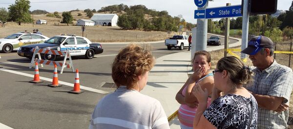 People gather at a road block near the entrance to Umpqua Community College, in Roseburg, Ore., Thursday, Oct. 1, 2015, following a deadly shooting at the campus. - Sputnik International