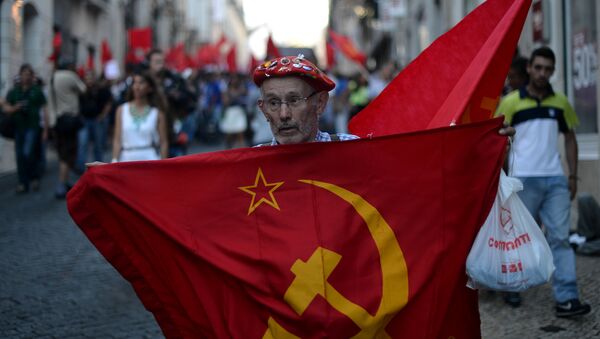 A demonstrator holds a communist flag in Lisbon. - Sputnik International