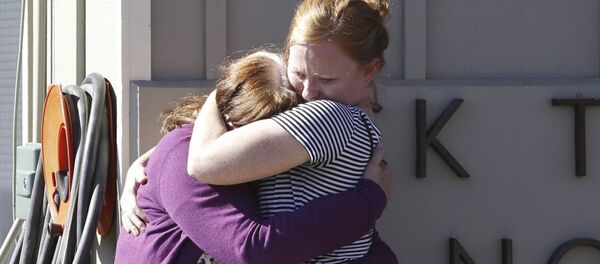 Umpqua Community College alumnus Donice Smith (L) is embraced after she said one of her former teachers was shot dead, near the site of a mass shooting at Umpqua Community College in Roseburg,Oregon October 1, 2015 Umpqua Community College alumnus Donice Smith (L) is embraced after she said one of her former teachers was shot dead, near the site of a mass shooting at Umpqua Community College in Roseburg,Oregon October 1, 2015 - Sputnik International
