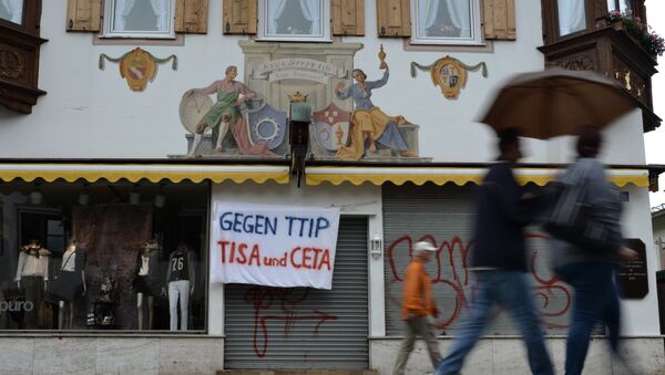 A banner reading 'Against TTIP, TiSA and CETA' hangs over the entrance of a shop in Garmisch-Partenkirchen, southern Germany - Sputnik International