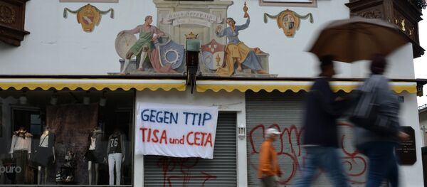 A banner reading 'Against TTIP, TiSA and CETA' hangs over the entrance of a shop in Garmisch-Partenkirchen, southern Germany - Sputnik International