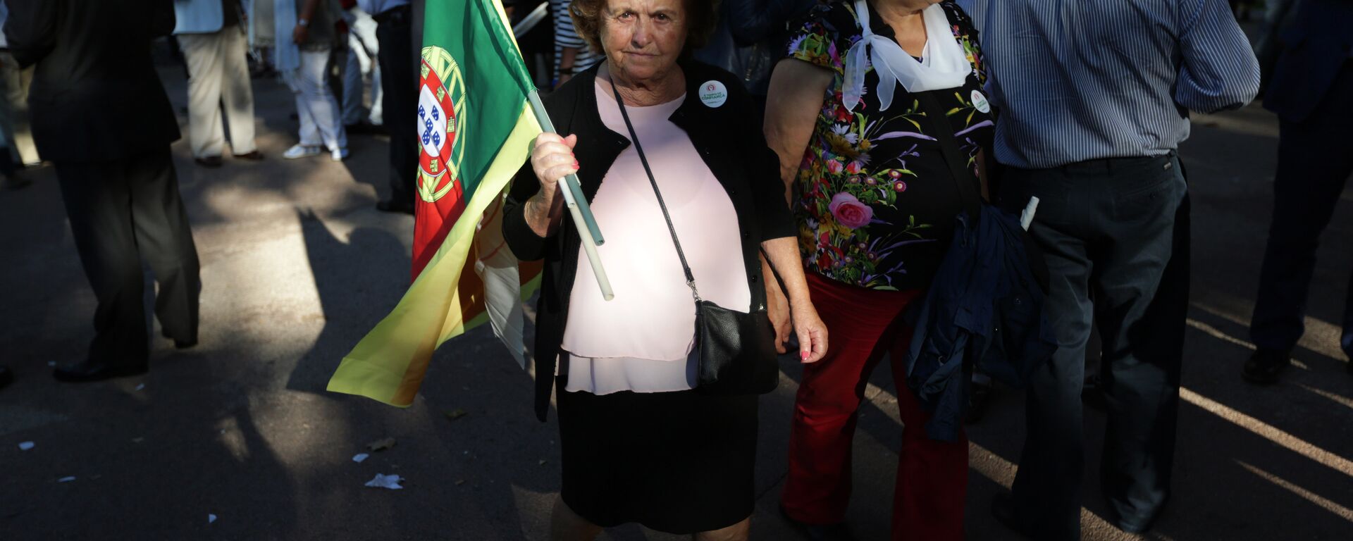 A supporter of the Portuguese Socialist Party carries a Portuguese flag while waiting for the arrival of the party leader Antonio Costa during a campaign action in Lisbon Tuesday, Sept. 29 2015. - Sputnik International, 1920, 11.03.2024