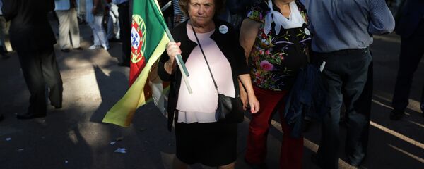 A supporter of the Portuguese Socialist Party carries a Portuguese flag while waiting for the arrival of the party leader Antonio Costa during a campaign action in Lisbon Tuesday, Sept. 29 2015. - Sputnik International