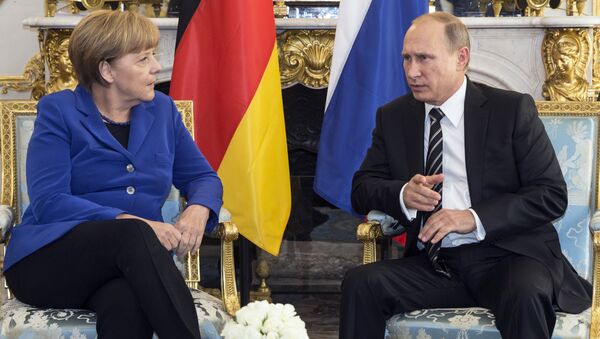 German Chancellor Angela Merkel, left, discusses with Russian President Vladimir Putin during a bilateral prior to a summit on Ukraine at the Elysee Palace in Paris, France - Sputnik International