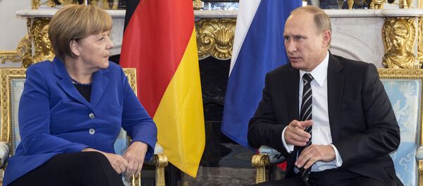 German Chancellor Angela Merkel, left, discusses with Russian President Vladimir Putin during a bilateral prior to a summit on Ukraine at the Elysee Palace in Paris, France - Sputnik International