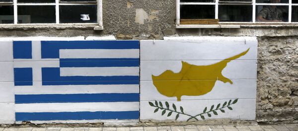 A representation of the Greek, left, and Cyprus flags are painted on a wall as a Greek Cypriot soldier is seen inside a guard post by the U.N controlled buffer zone as they cuts across the Cypriot divided capital Nicosia - Sputnik International