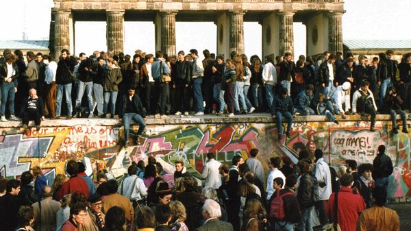 People walking on the Berlin wall in front of the Brandenburg gate after opening one day before, Nov. 10, 1989 - Sputnik International