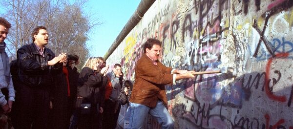 An unidentified West Berliner swings a sledgehammer, trying to destroy the Berlin Wall near Potsdamer Platz, on November 12, 1989, where a new passage was opened nearby An unidentified West Berliner swings a sledgehammer, trying to destroy the Berlin Wall near Potsdamer Platz, on November 12, 1989, where a new passage was opened nearby - Sputnik International