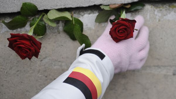 A woman places a rose in the former Berlin wall after a commemoration of the 20th anniversary of the fall of the Berlin Wall on 9 November 1989 at the wall memorial Bernauer Strasse in Berlin, Germany, on 9 November 2009 - Sputnik International