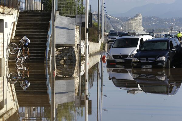 A man carrying his bicycle tries to make his way after floods in Biot, near Cannes, southeastern France - Sputnik International