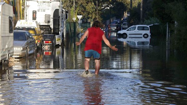 A man reacts as he wades through flood waters near cars after flooding caused by torrential rain in Biot, France - Sputnik International