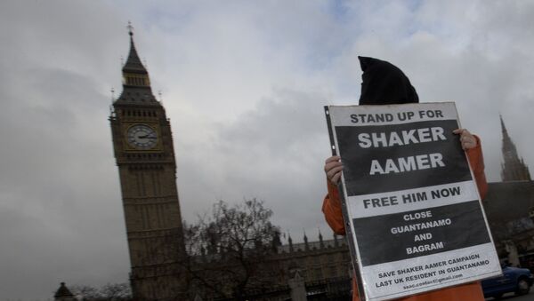 A hooded protester demonstrates for a Guantanamo detainee Shaker Aamer outside the Palace of Westminster in London, Wednesday, Jan. 15, 2014. - Sputnik International