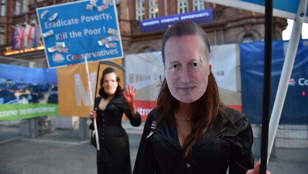 Demonstrators wear masks depicting Prime Minister David Cameron and Chancellor of the Exchequer George Osborne whilst holding placards as they march through the streets of Manchester in protest against the British Conservative government, on the first day of the annual Conservative party conference in Manchester, north west England, on October 4, 2015. - Sputnik International