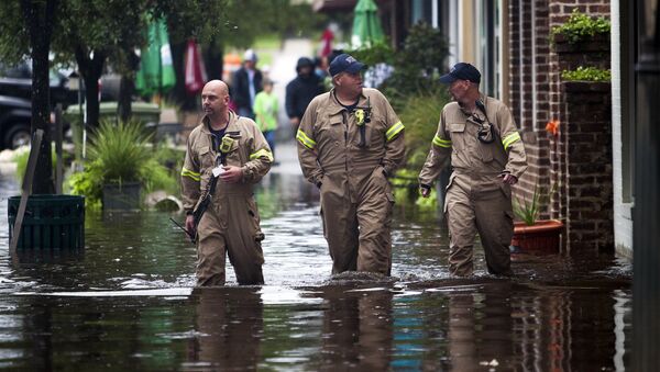 (L-R) Norman Beauregard, Kevin Attender and Chris Rogers of the Georgetown Fire Department, wade through flooded Front Street in Georgetown, South Carolina October 4, 2015. - Sputnik International