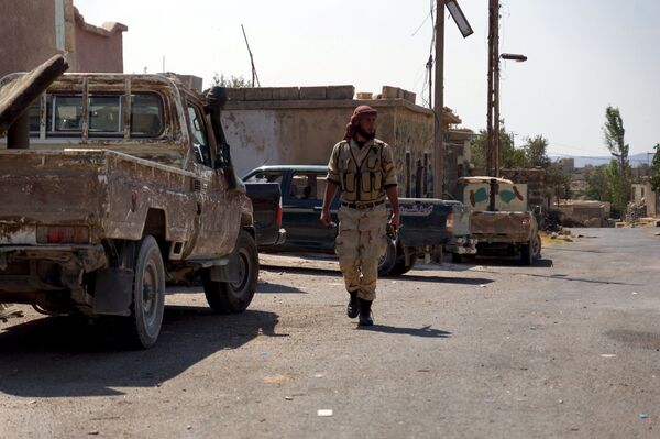 A Free Syrian Army fighter walks near military vehicles during what they said was preparations for an operation to strike at forces loyal to Syria's president Bashar Al-Assad in order to break a siege on the city of Beit Gin located in western countryside of Damascus in Deraa, Syria September 30, 2015 - Sputnik International