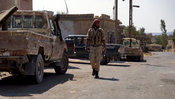 A Free Syrian Army fighter walks near military vehicles during what they said was preparations for an operation to strike at forces loyal to Syria's president Bashar Al-Assad in order to break a siege on the city of Beit Gin located in western countryside of Damascus in Deraa, Syria September 30, 2015 - Sputnik International
