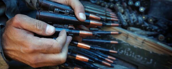A fighter prepares an ammunition belt. - Sputnik International