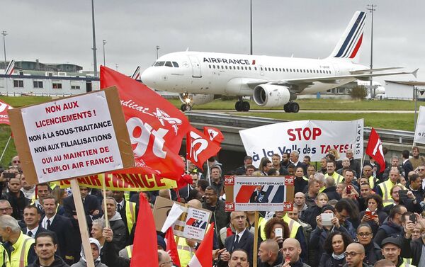 Striking employees of Air France demonstrate in front of the Air France headquarters building at the Charles de Gaulle International Airport in Roissy, near Paris, France, October 5, 2015. Air France confirmed in a meeting with staff on Monday that it plans to cut 2,900 jobs by 2017 and shed 14 aircraft from its long-haul fleet as part of efforts to lower costs, two union sources said. - Sputnik International