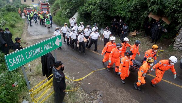 Rescue team members carry the bodies of mudslide victims toward the coroner's truck, in Santa Catarina Pinula - Sputnik International