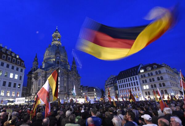 Protestors wave a German flag in front of the Church of Our Lady during a demonstration of PEGIDA (Patriotic Europeans against the Islamization of the West) in Dresden, eastern Germany, Monday, Oct. 5, 2015. Protestors wave a German flag in front of the Church of Our Lady during a demonstration of PEGIDA (Patriotic Europeans against the Islamization of the West) in Dresden, eastern Germany, Monday, Oct. 5, 2015. - Sputnik International