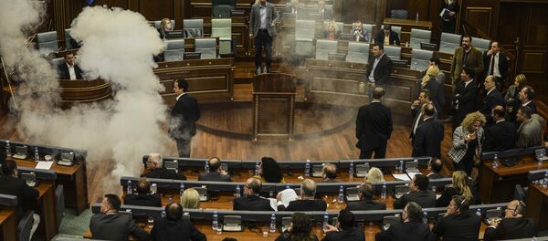 A white cloud of tear gas ascends after being released by opposition lawmakers in Kosovo's parliament in Pristina, on October 8, 2015 causing two MPs to faint, in protest at a recent EU-brokered deal reached by the government with Serbia - Sputnik International