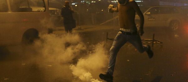 A Lebanese anti-government protester kicks back a tear gas canister shot by security forces during a protest against the ongoing trash crisis and government corruption, in downtown Beirut, Lebanon, Thursday, Oct. 8, 2015. Lebanese security forces used water cannons and eventually fired tear gas canisters to disperse dozens of anti-government protesters who tried to get past security barricades and reach parliament. - Sputnik International