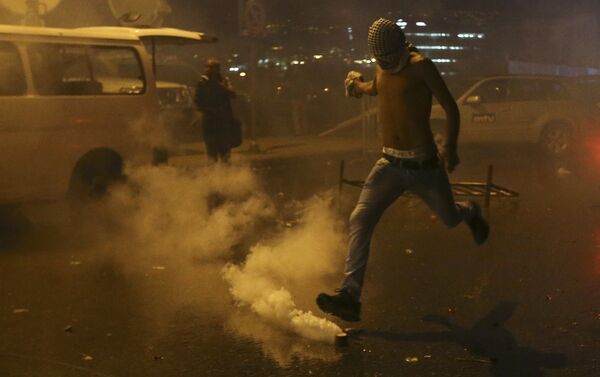 A Lebanese anti-government protester kicks back a tear gas canister shot by security forces during a protest against the ongoing trash crisis and government corruption, in downtown Beirut, Lebanon, Thursday, Oct. 8, 2015. Lebanese security forces used water cannons and eventually fired tear gas canisters to disperse dozens of anti-government protesters who tried to get past security barricades and reach parliament. - Sputnik International