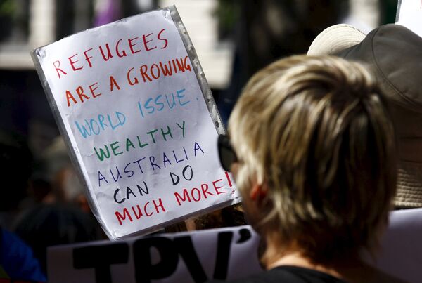 Protesters hold placards at the 'Stand up for Refugees' rally held in central Sydney. Australia is negotiating a deal with the Philippines to transfer asylum seekers being held indefinitely in controversial detention centres on remote, impoverished islands, Australia's immigration minister said on October 9, 2015 Protesters hold placards at the 'Stand up for Refugees' rally held in central Sydney. Australia is negotiating a deal with the Philippines to transfer asylum seekers being held indefinitely in controversial detention centres on remote, impoverished islands, Australia's immigration minister said on October 9, 2015 - Sputnik International