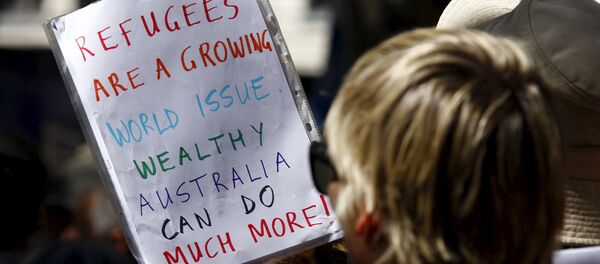 Protesters hold placards at the 'Stand up for Refugees' rally held in central Sydney. Australia is negotiating a deal with the Philippines to transfer asylum seekers being held indefinitely in controversial detention centres on remote, impoverished islands, Australia's immigration minister said on October 9, 2015 - Sputnik International