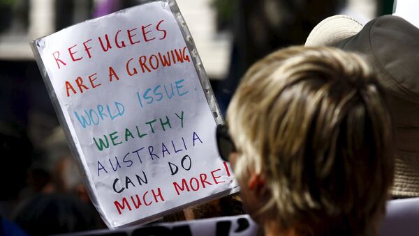Protesters hold placards at the 'Stand up for Refugees' rally held in central Sydney. Australia is negotiating a deal with the Philippines to transfer asylum seekers being held indefinitely in controversial detention centres on remote, impoverished islands, Australia's immigration minister said on October 9, 2015 - Sputnik International