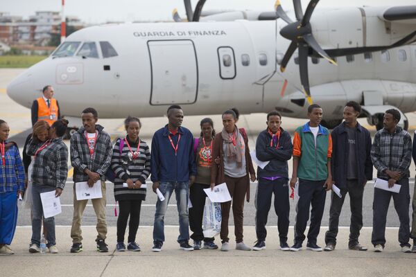 Eritrean refugee pose for a group photo in front of an Italian Financial police aircraft which will take them to Sweden, at Rome's Ciampino airport, Friday, Oct. 9, 2015. Eritrean refugee pose for a group photo in front of an Italian Financial police aircraft which will take them to Sweden, at Rome's Ciampino airport, Friday, Oct. 9, 2015. - Sputnik International