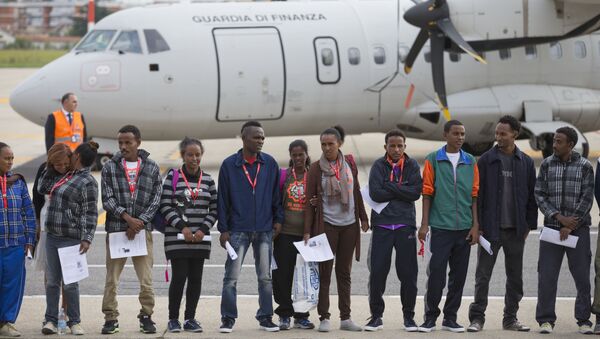 Eritrean refugee pose for a group photo in front of an Italian Financial police aircraft which will take them to Sweden, at Rome's Ciampino airport, Friday, Oct. 9, 2015. (No reference to people mentioned in the article)) - Sputnik International