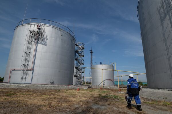 An employee of Gazprom-Neft's Novosibirsk petroleum base near fuel storage tanks An employee of Gazprom-Neft's Novosibirsk petroleum base near fuel storage tanks - Sputnik International