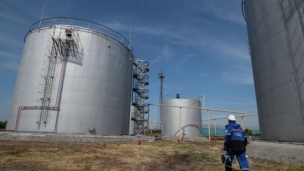 An employee of Gazprom-Neft's Novosibirsk petroleum base near fuel storage tanks - Sputnik International