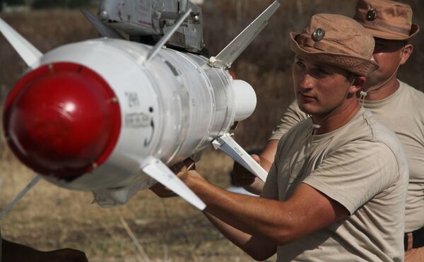 Russian servicemen attach a Kh-25 high-precision missile to a Su-24 aircraft at the Khmeimim airbase in Syria. File photo  - Sputnik International