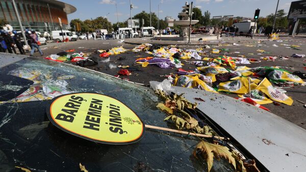 A placard that reads in Turkish: 'Peace Immediately Now' , is seen at the site of an explosion with the bodies of victims covered with flags and banners in the background, in Ankara, Turkey - Sputnik International