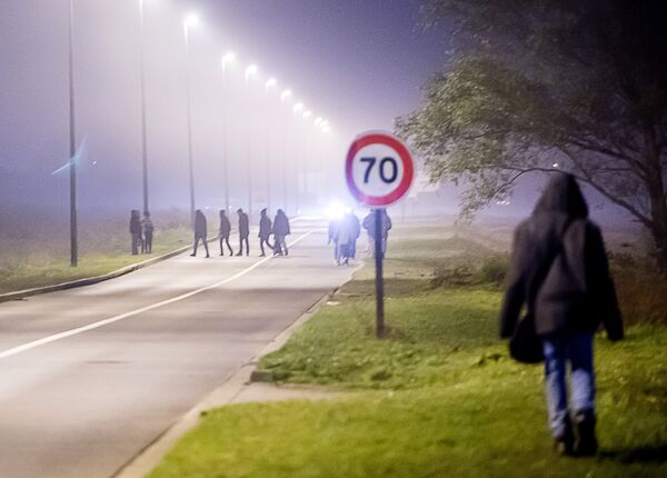 Migrants walk on a road towards the Eurotunnel site in Coquelles, northern France, on October 3, 2015. Migrants walk on a road towards the Eurotunnel site in Coquelles, northern France, on October 3, 2015. - Sputnik International