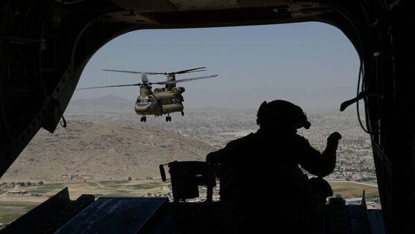 This photo taken on august 11, 2014 shows a US soldier, part of the NATO-led International Security Assistance Force (ISAF), manning a machine gun onboard a Chinook helicopter over the Gardez district of Paktia province - Sputnik International