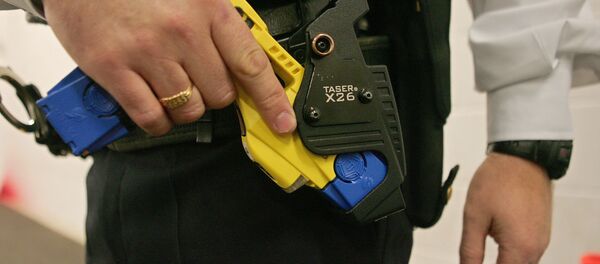 A file photo taken 05 December 2007 shows a British police officer holding a taser gun during a training session at the Metropolitan Police Specialist Training Centre, in Gravesend, Kent, in southeast England A file photo taken 05 December 2007 shows a British police officer holding a taser gun during a training session at the Metropolitan Police Specialist Training Centre, in Gravesend, Kent, in southeast England - Sputnik International