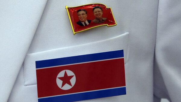 A pin of late North Korea leaders Kim Il Sung and Kim Jong Il and North Korea's flag are displayed on a North Korean reporter's jacket at the Main Media Center for the 17th Asian Games in Incheon, west of Seoul, South Korea - Sputnik International