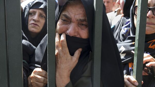 An Iranian mourner weeps during a funeral ceremony, attended by thousands of mourners in Tehran, Iran, for some of the pilgrims who were killed in a stampede during the hajj pilgrimage in Saudi Arabia in September 2015. - Sputnik International