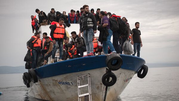Migrants and refugees are seen aboard a Turkish fishing boat as they arrive on the Greek island of Lesbos after crossing a part of the Aegean Sea from theTurkish coast to Lesbos October 11, 2015 - Sputnik International